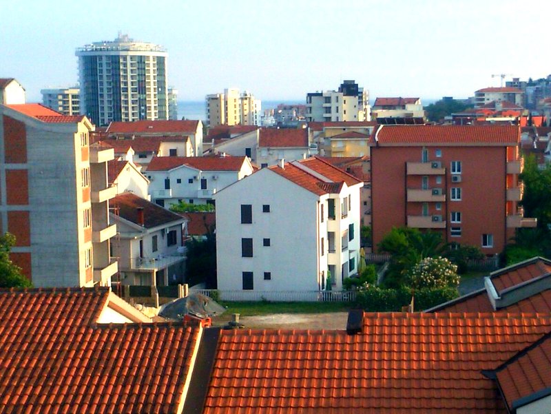Panoramablick auf ein Wohnviertel mit roten Ziegeldächern und modernen Häusern in Budva, Montenegro.