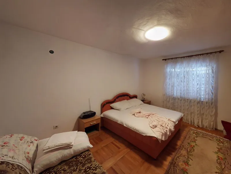 Gemütliches Schlafzimmer mit Doppelbett und Parkett in einem Haus zum Verkauf, Stadtteil Šušanj, Montenegro.