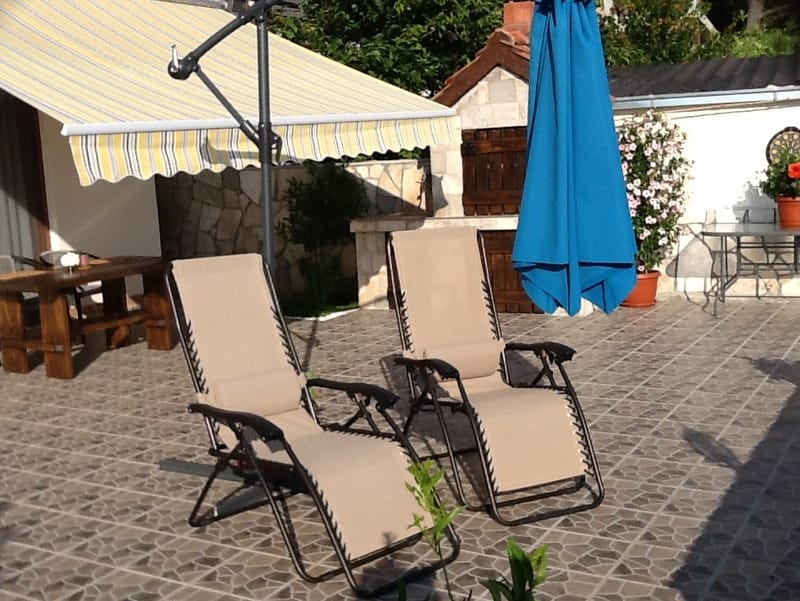 Cozy terrace with loungers, a barbecue area, and a canopy by the house in Shushan, Montenegro for comfortable outdoor relaxation