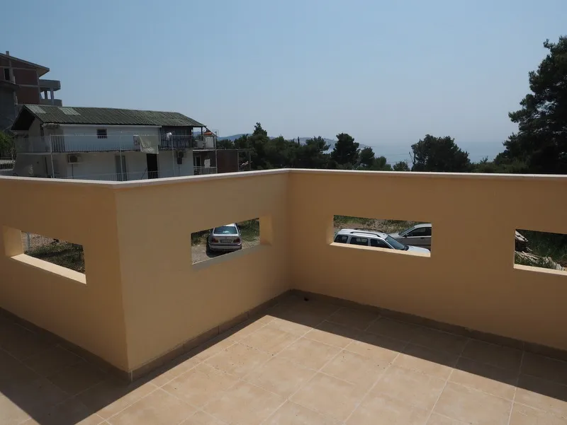 Geräumige offene Terrasse mit Fliesenbelag in einem Haus in Bar, Montenegro, mit Blick auf das Meer und die Umgebung.