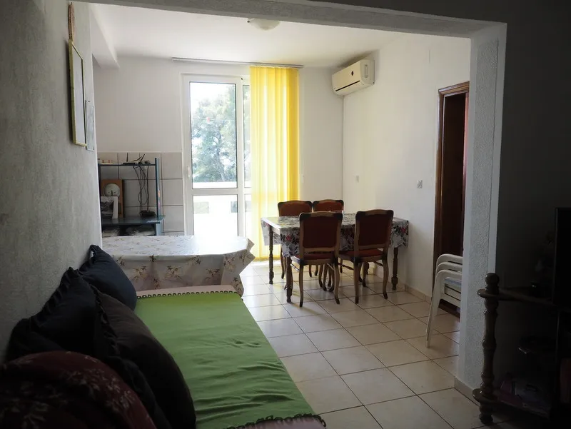 Wohnzimmer mit Essbereich in einem Haus in Bar, Montenegro: heller Raum mit Fliesen, Möbeln und Zugang zur Terrasse.