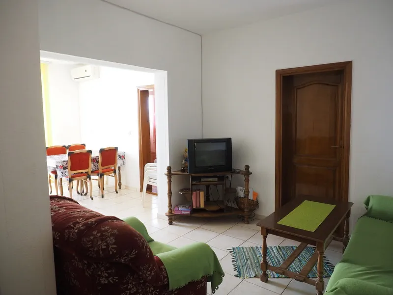 Wohnzimmer mit Polstermöbeln und Essbereich in einem Haus zum Verkauf, Stadt Bar, Montenegro. Helles Interieur mit Fliesen.