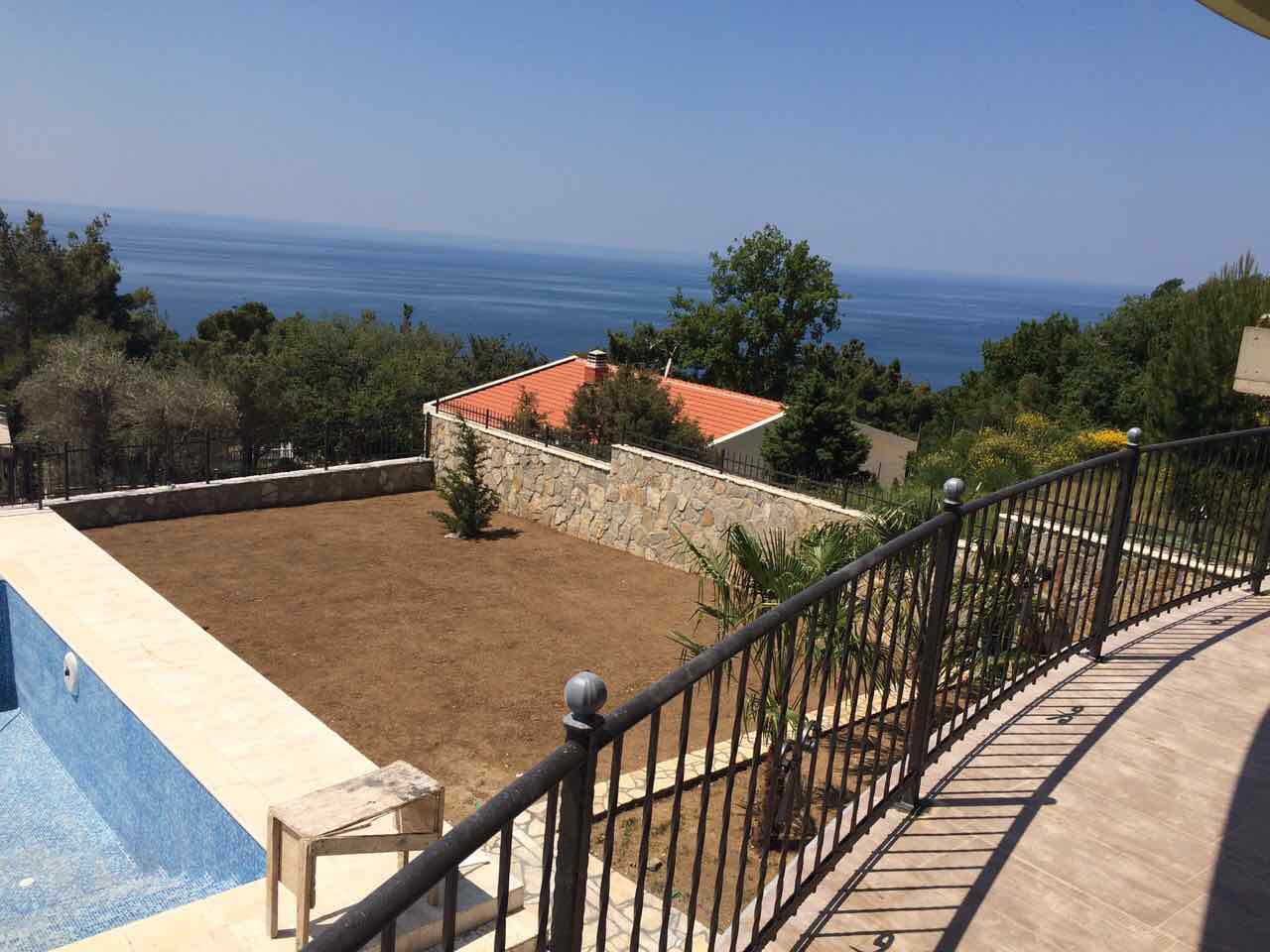 Pogled sa terase vile u Šušnju, Crna Gora: privatni bazen, baštenska parcela i panoramski pogled na Jadransko more.