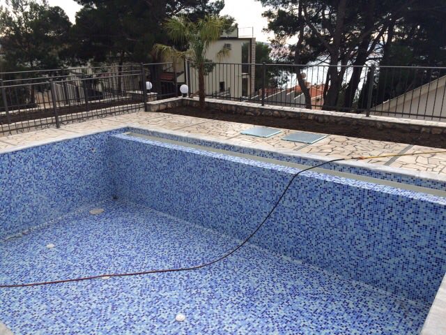 Offener Pool mit Mosaikverkleidung auf der Terrasse des Hauses in Šušanj, Montenegro, mit Blick auf das Meer und die Pinien.