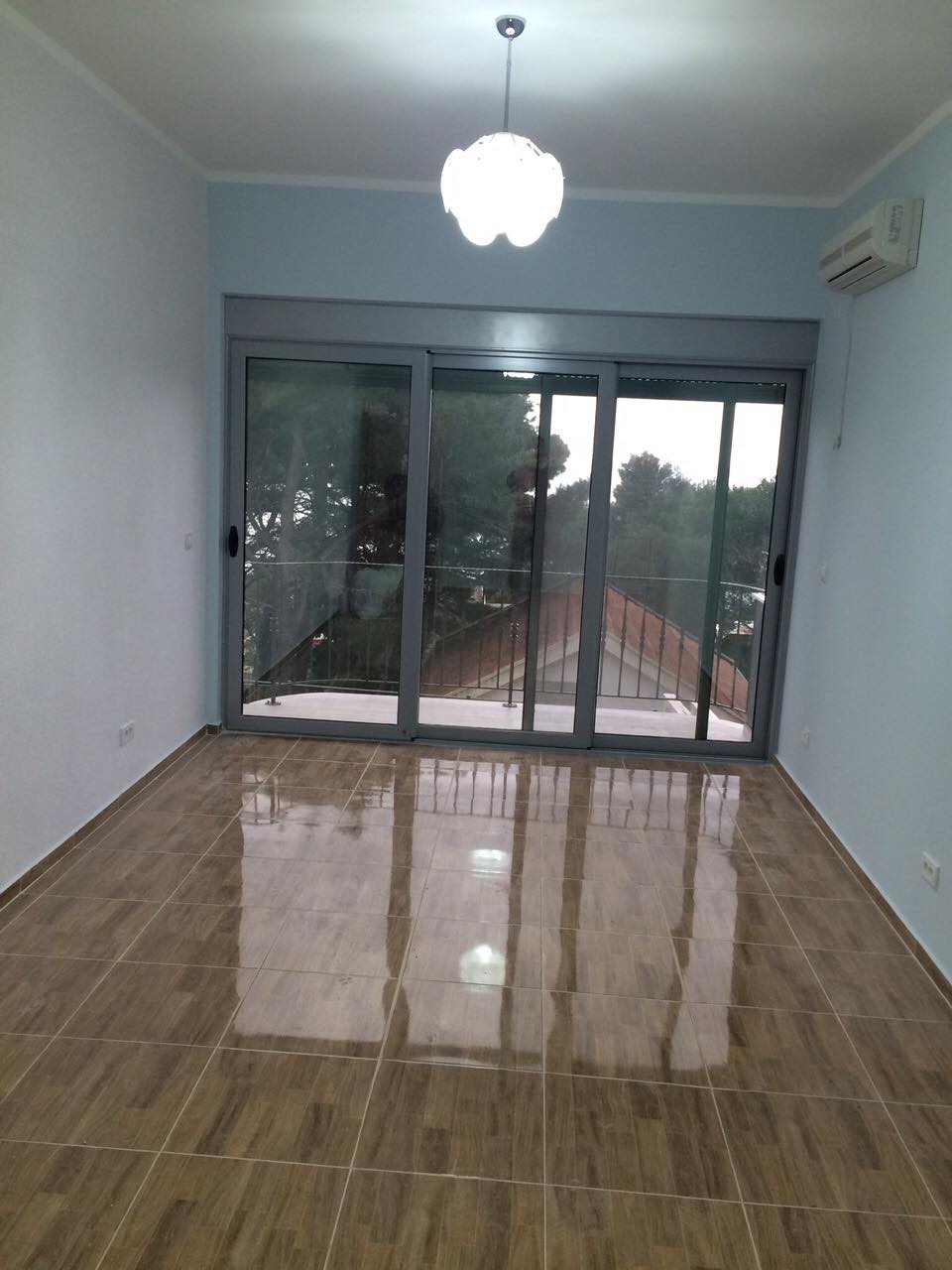 Helles Wohnzimmer mit Panoramafenster und Zugang zum Balkon in einem Haus, Shushan, Montenegro. Fliesenboden, Klimaanlage.