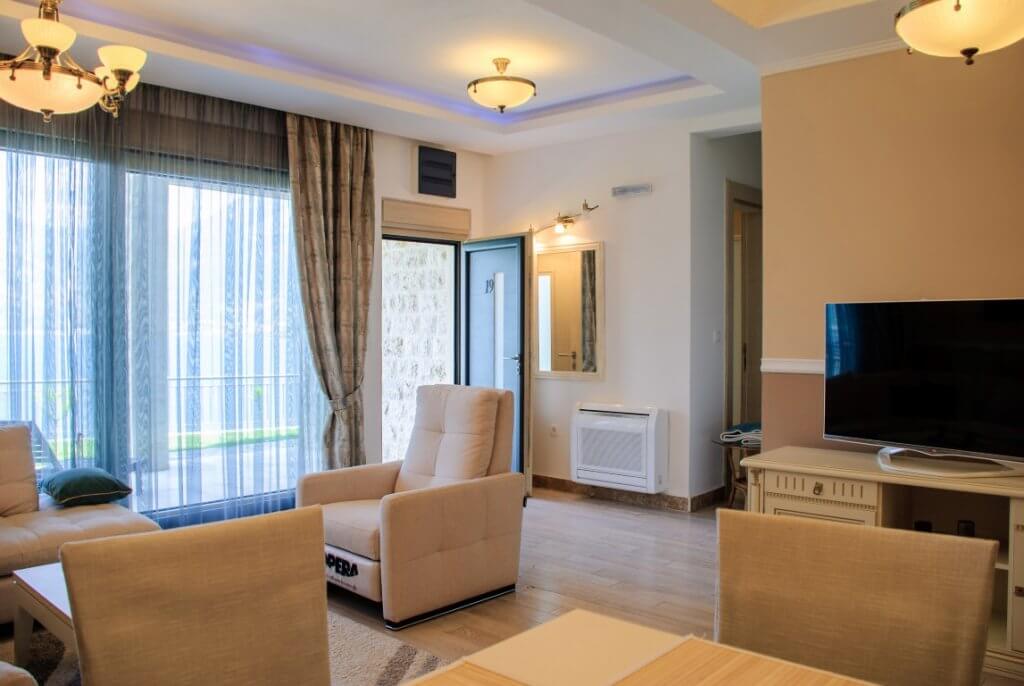 Salon confortable avec mobilier moelleux et accès à la terrasse dans l’appartement, Kostanica, Monténégro.