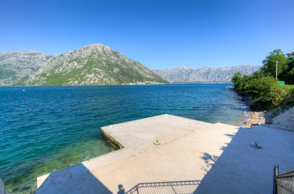 Jetée privée en béton au bord de la mer avec vue panoramique sur les montagnes et la baie de Kotor, Kostanica, Monténégro.