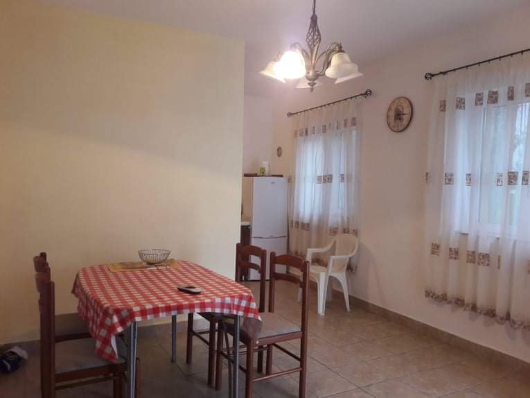 Gemütlicher Essbereich mit Küche im Hotel in Budva, Montenegro: Holztisch, Stühle und helles Interieur.
