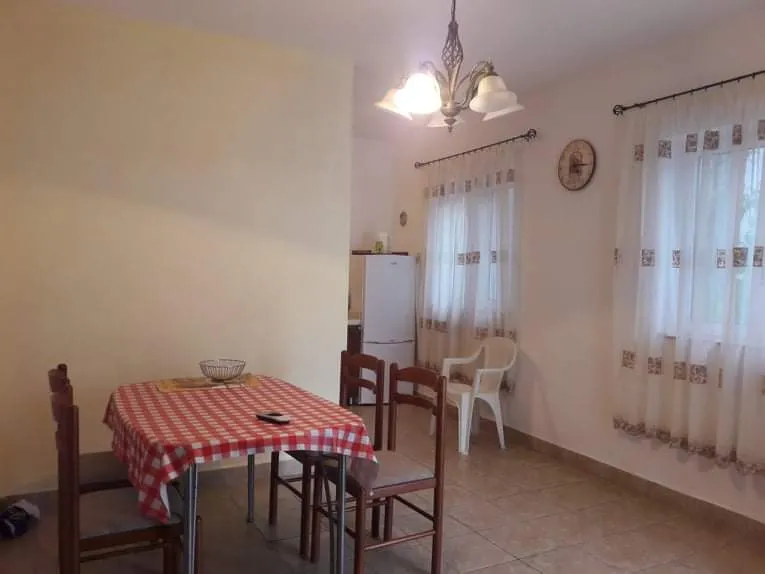 Gemütlicher Essbereich mit Küche im Hotel in Budva, Montenegro: Holztisch, Stühle und helles Interieur.