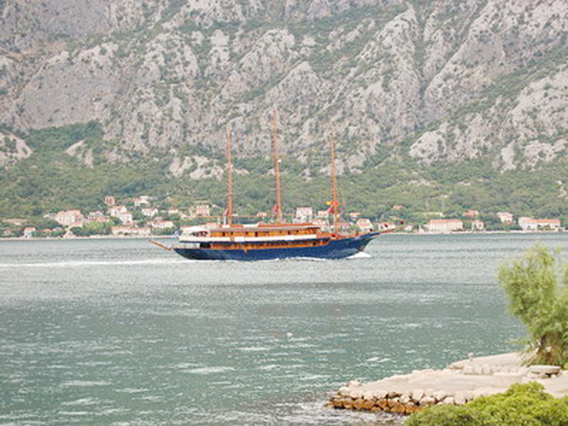 Blick auf das Meer und eine Segelyacht von der Villa in Prčanj, Montenegro: Panorama der Bucht und der Berglandschaft an der Küste.