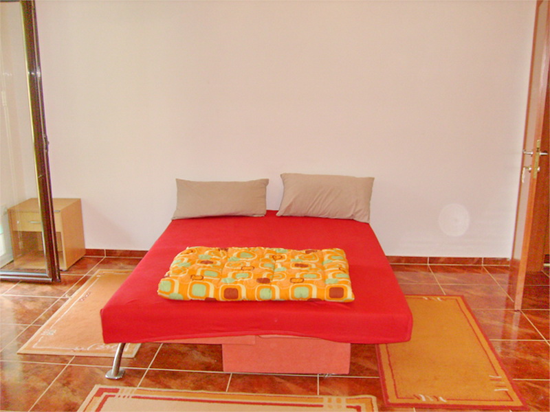 Schlafzimmer mit Doppelbett und Fliesenboden in einer Villa in Prčanj, Montenegro. Gemütliches Interieur zum Entspannen.