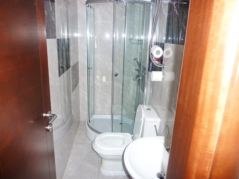 Modernes Badezimmer mit Duschkabine in einer Wohnung, Rafailovici, Montenegro: Fliesenverkleidung und Sanitäranlagen.
