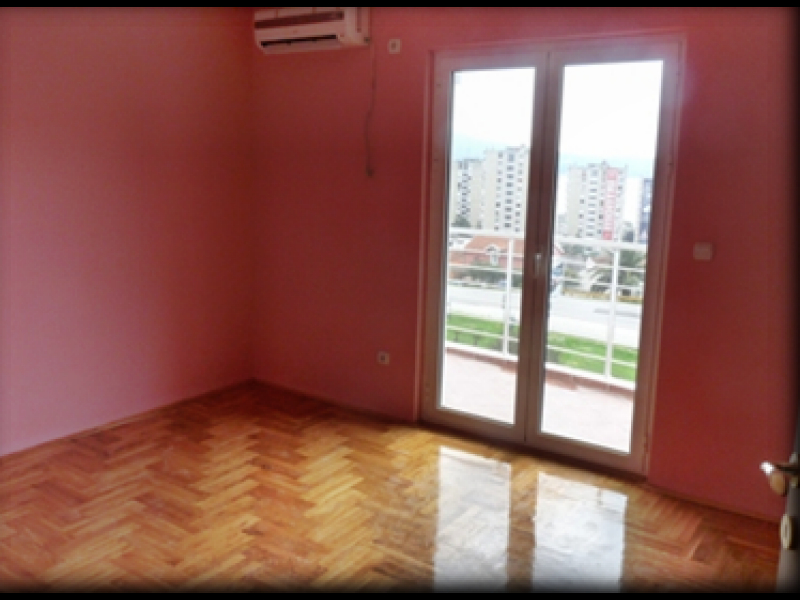 Salon lumineux avec parquet et accès au balcon dans un appartement, Igalo, Monténégro. Vue sur la ville et climatisation.