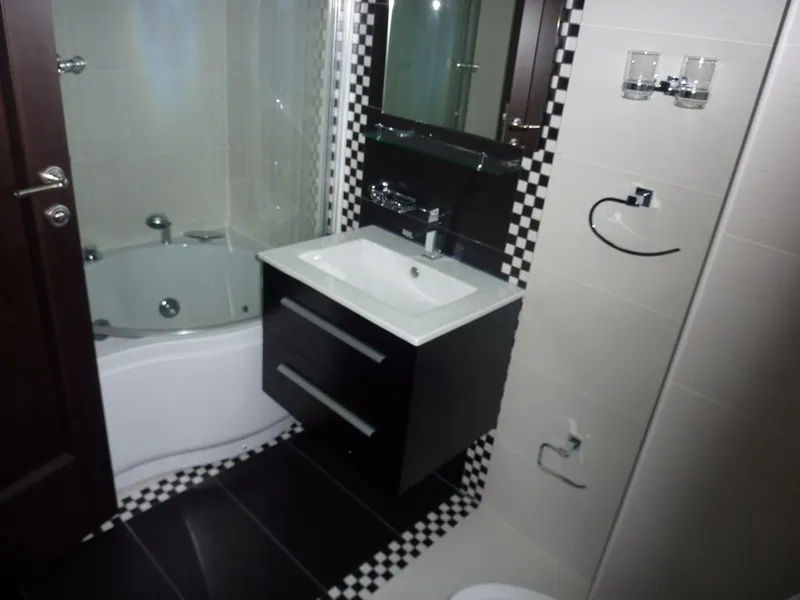 Geräumiges Badezimmer mit Eckbadewanne und schwarzem Waschtisch