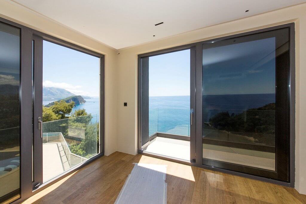 Wohnzimmer mit Panoramafenstern und Meerblick in einer exklusiven Villa in Budva, Montenegro: modernes Interieur, Terrasse.