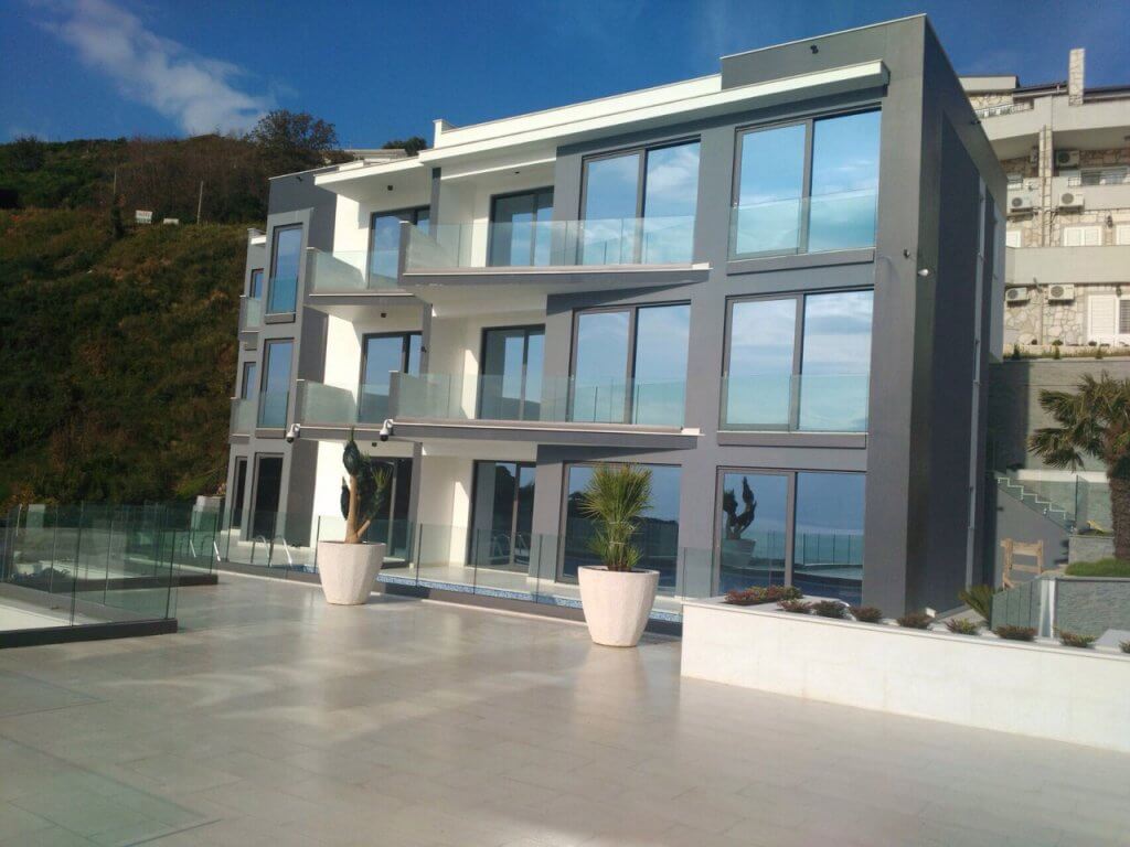 Moderne Villa in Budva, Montenegro: Fassade mit Panoramafenstern, Glasbalkonen und Poolterrasse.