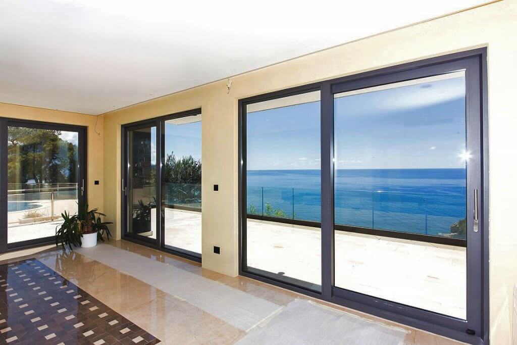 Wohnzimmer mit Panoramafenstern und Meerblick in einer Villa in Budva, Montenegro: helles Interieur und Terrasse.