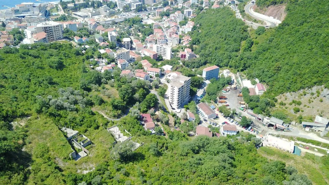Luftaufnahme einer Küstenstadt eingebettet in ein üppig grünes Tal.