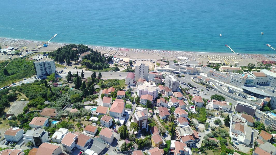 Luftaufnahme eines Grundstücks in Bečići, Montenegro: Panorama der Küste, des Strandes und der Bebauung am Meer.