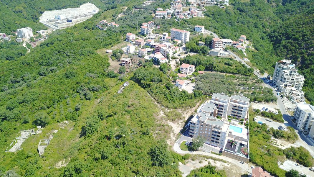Luftaufnahme eines Grundstücks und einer Wohnanlage mit Pool in Bečići, Montenegro. Panorama der Berglandschaft.