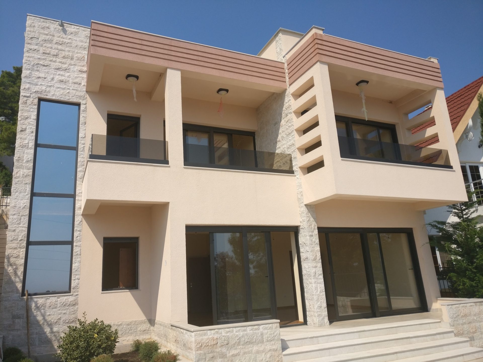 Modernes zweistöckiges Haus mit Panoramafenstern und Terrassen in Šušanj, Montenegro — Blick auf die Fassade des Gebäudes.