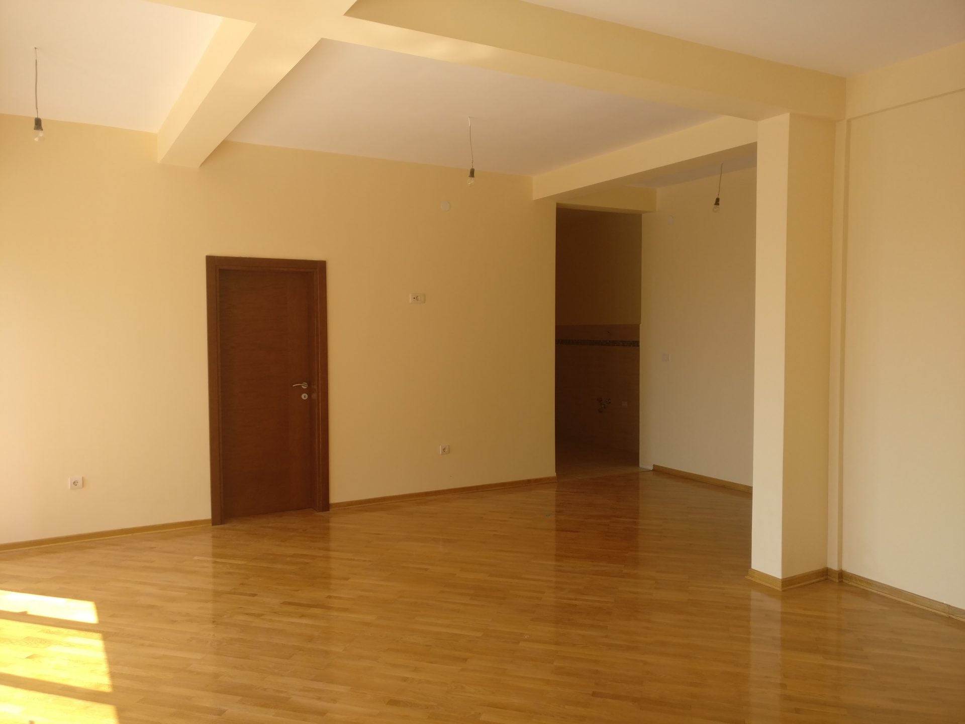 Geräumiges Wohnzimmer mit Parkettboden und hellen Wänden in einem Haus zum Verkauf, Šušanj, Montenegro.