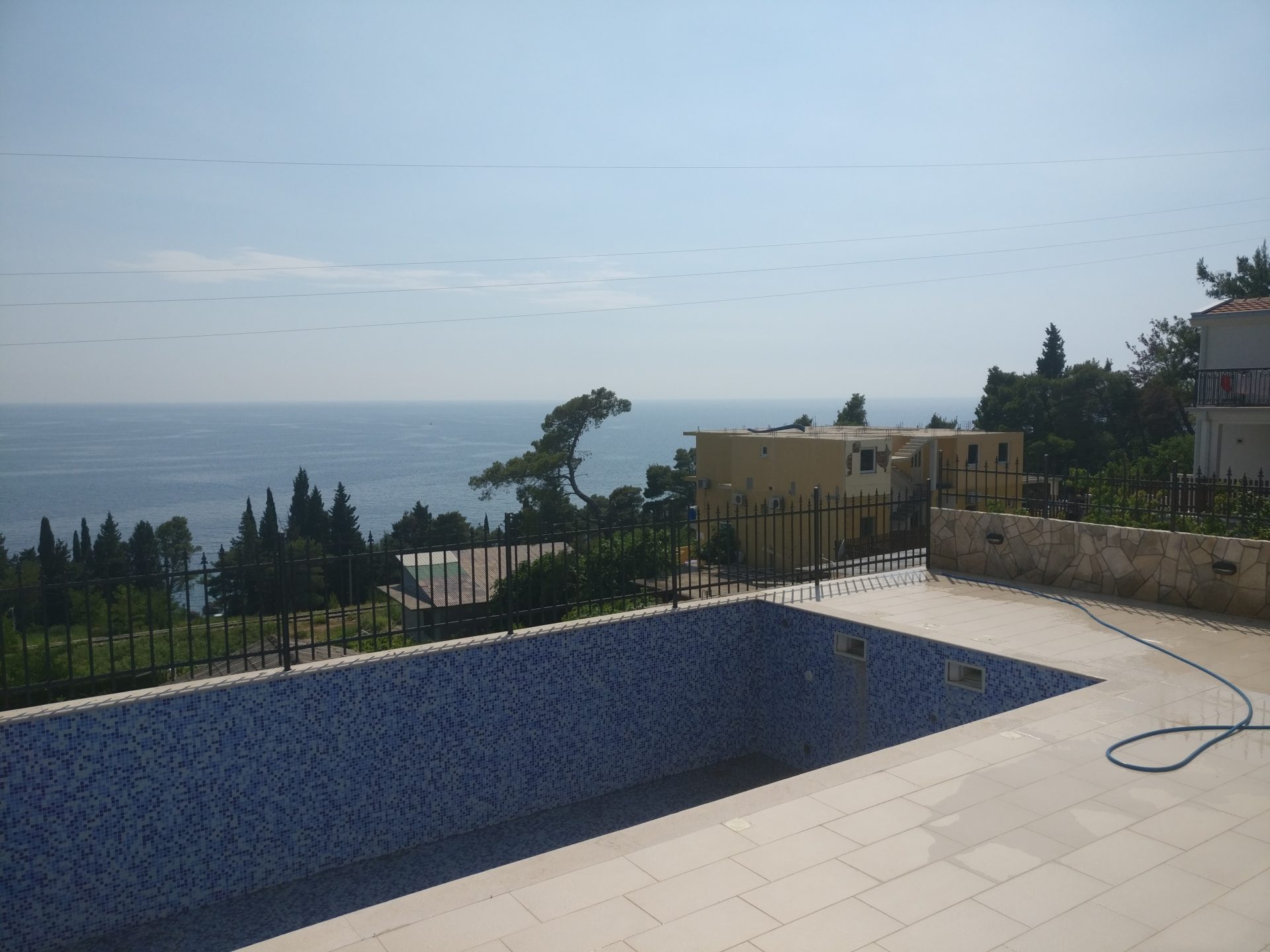 Meerblick und Pool mit Mosaikverkleidung auf der Terrasse des Hauses in Šušanj, Montenegro.