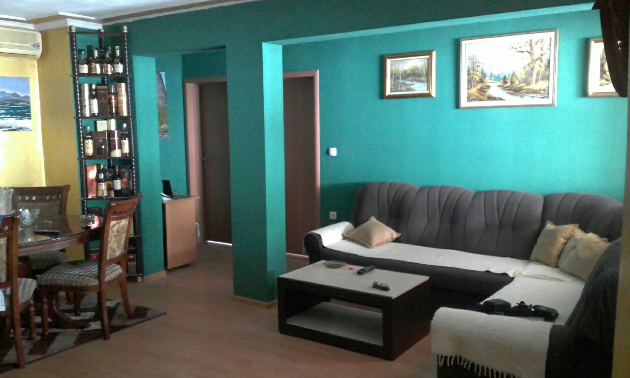 Wohnzimmer mit türkisfarbenen Wänden, Ecksofa und Essbereich in einem Haus, Šušanj, Montenegro.