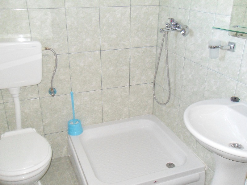 Ванная комната с душевой кабиной и светлой плиткой в доме на продажу, Добрые Воды, Черногория.