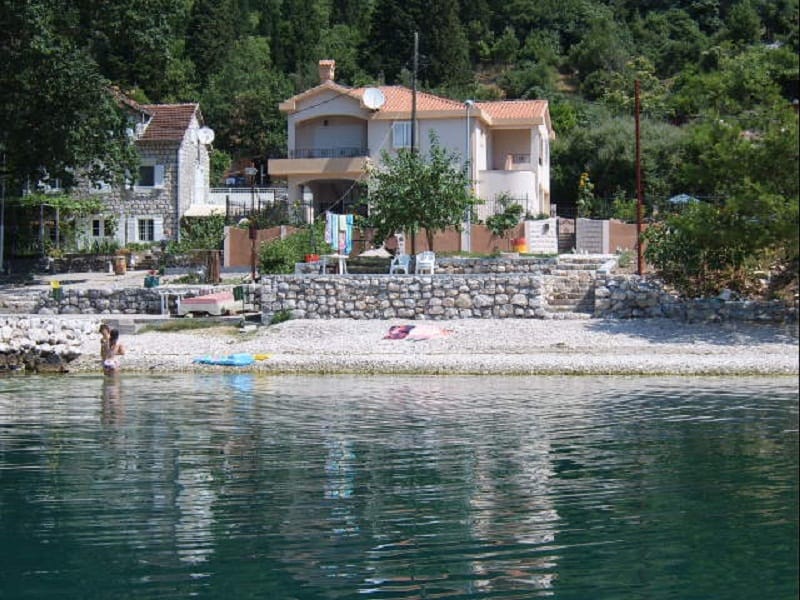 Maison à deux étages avec terrasse en première ligne de mer à Orahovac, Monténégro, avec plage de galets privée et jardin.