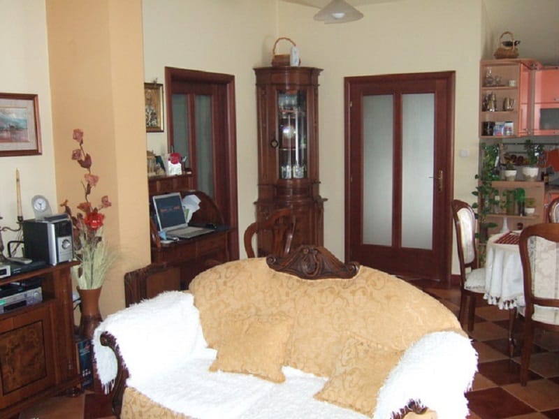 Intérieur du salon dans une maison à Orahovac, Monténégro : mobilier classique en bois, canapé moelleux et coin repas.
