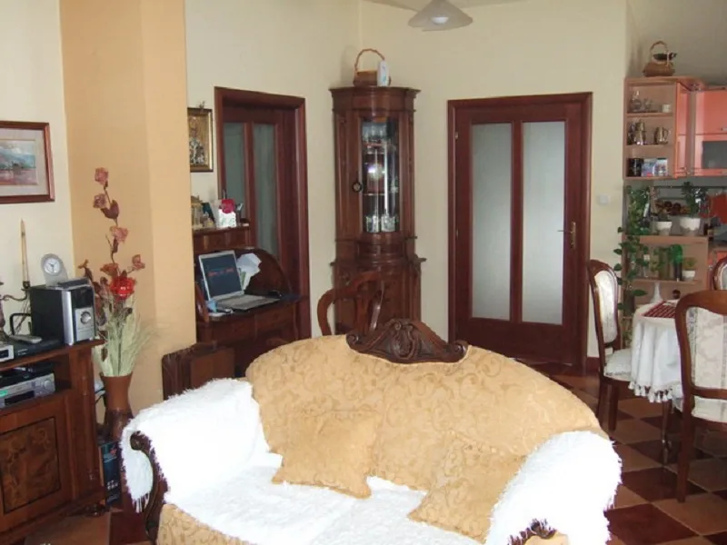Living room interior in a house in Orahovac, Montenegro: classic wooden furniture, a soft sofa, and a dining area.