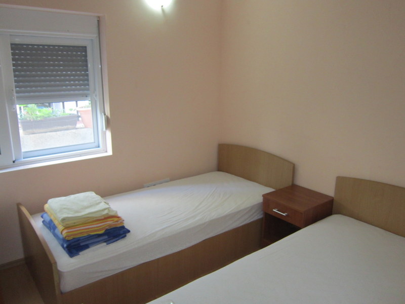 Schlafzimmer mit zwei Einzelbetten und Nachttisch in einem Haus zum Verkauf, Uteha, Montenegro.