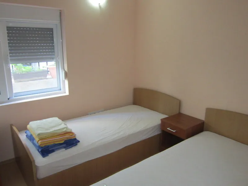 Bedroom with two single beds and a bedside table in a house for sale, Utjeha, Montenegro.