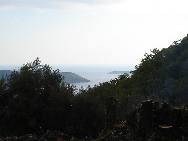 Panoramiczny widok na morze i góry z działki w Herceg Novi, Czarnogóra, otoczonej bujną zielenią.