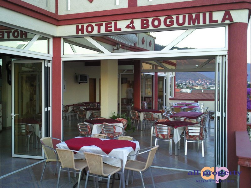 Otwarty taras restauracji hotelu Bogumila w mieście Bar, Czarnogóra, ze stolikami i panoramicznym widokiem na góry.