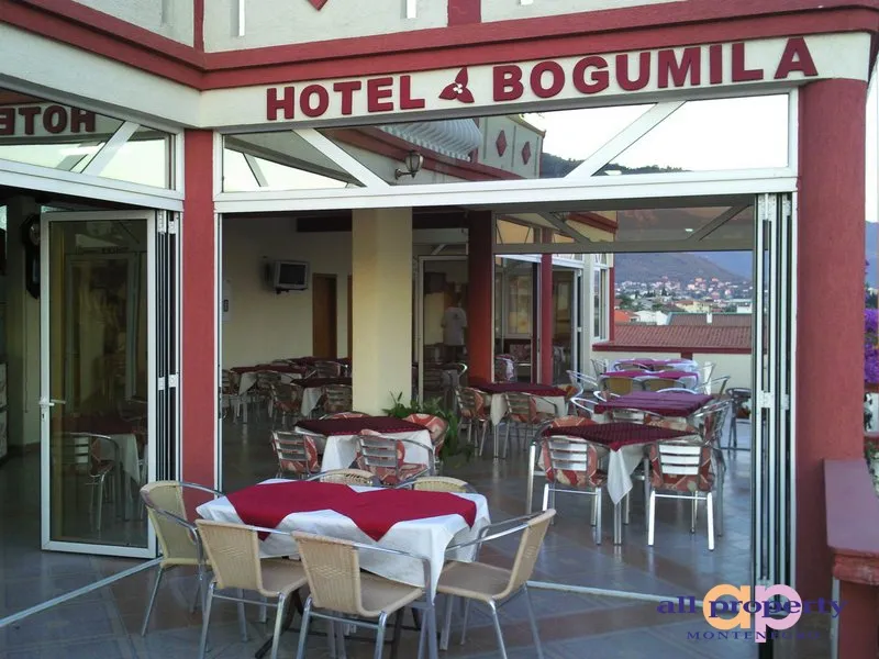 Offene Terrasse des Hotels Bogumila in Bar, Montenegro, mit Tischen und Panoramablick auf die Berge.