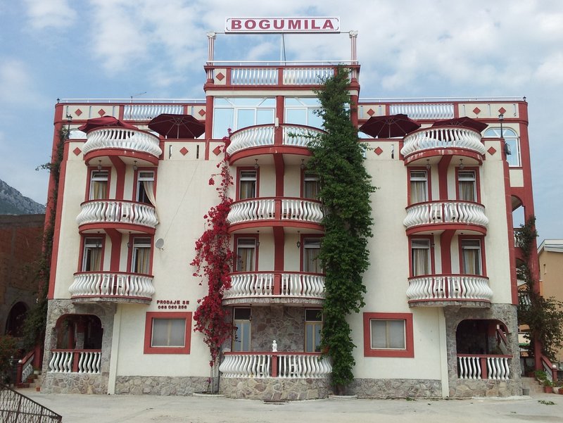 Fasada hotelu Bogumila w mieście Bar, Czarnogóra: czteropiętrowy budynek z balkonami, tarasem i elementami dekoracyjnymi.