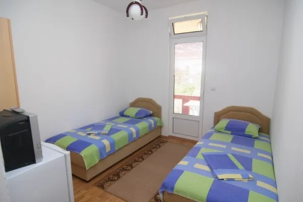 Schlafzimmer mit zwei Einzelbetten in einem Hotel in Bar, Montenegro, mit Zugang zum Balkon und heller Ausstattung.