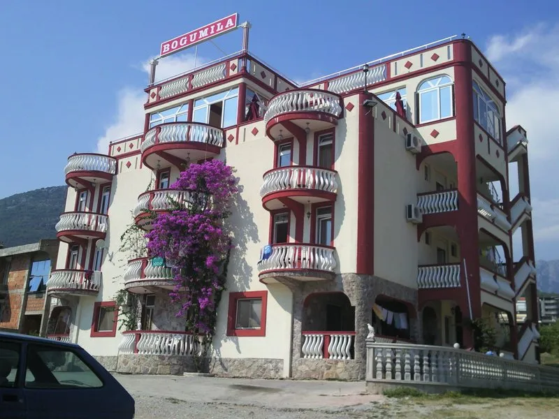 Fassade des Hotels Bogumila in der Stadt Bar, Montenegro: vierstöckiges Gebäude mit halbrunden Balkonen und blühender Bougainvillea.