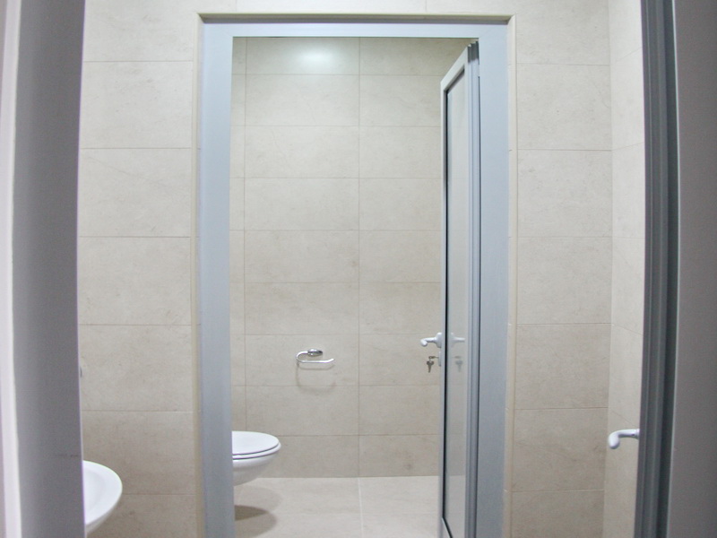 Modernes Badezimmer in einem Büro in Budva, Montenegro: helle Fliesen, hochwertige Sanitäranlagen und stilvolle Ausstattung.