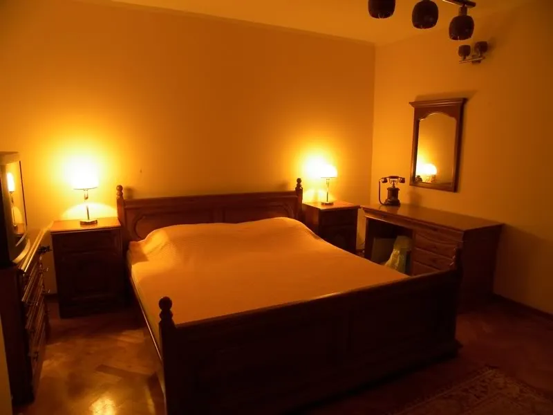 Gemütliches Schlafzimmer mit klassischen Holzmöbeln in einem Haus zum Verkauf in Budva, Montenegro: Doppelbett und Nachttische.