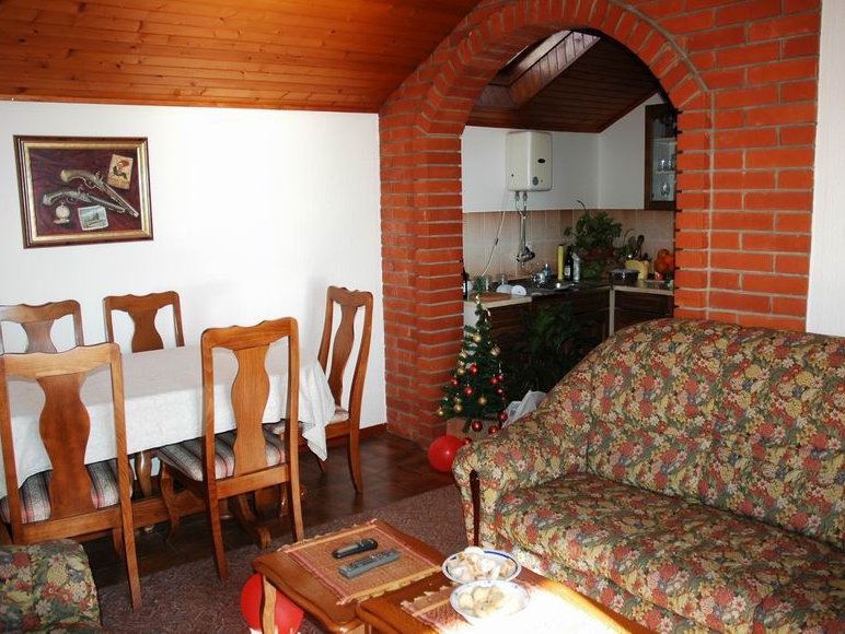 Wohnzimmer in einem Haus in Herceg Novi, Montenegro: Ziegelbogen, Holzdecke, Essbereich und ein bequemes Sofa.