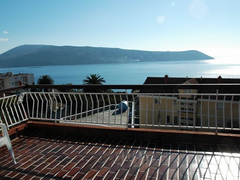 Blick von der Terrasse eines Hauses in Herceg Novi, Montenegro: Panorama auf die Adria, die Berge und den gefliesten Balkonboden.