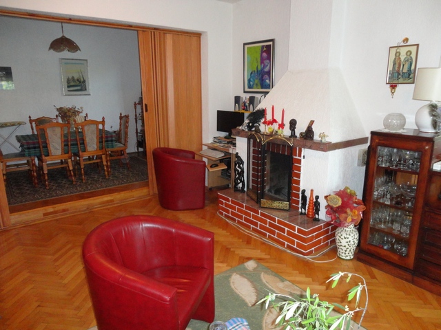 Wohnzimmer mit Kamin und roten Sesseln in einem Haus zum Verkauf, Herceg Novi, Montenegro: Innenraum mit Essbereich.