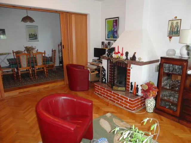 Wohnzimmer mit Kamin und roten Sesseln in einem Haus zum Verkauf, Herceg Novi, Montenegro: Innenraum mit Essbereich.