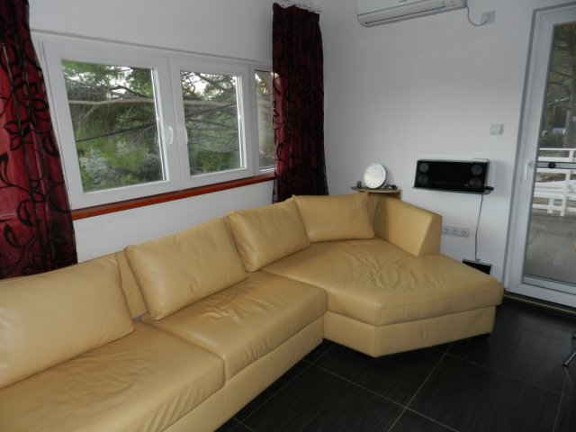 Living room with a leather sofa and access to the terrace in a house, Bar, Montenegro. Bright interior with a panoramic window.