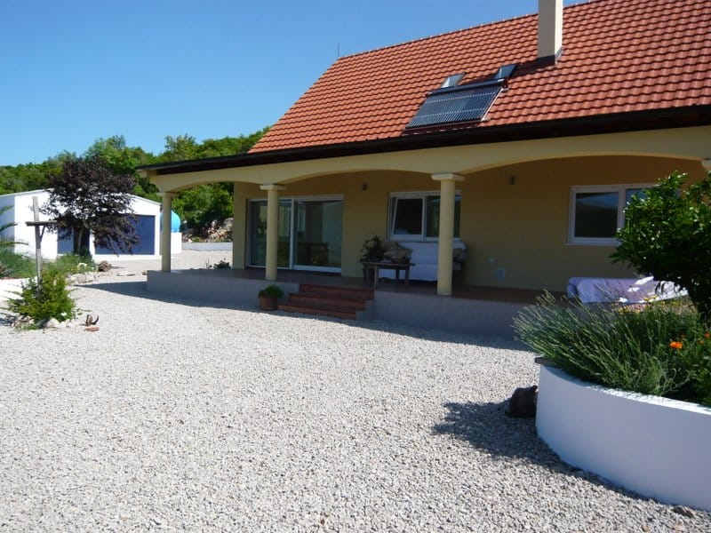 Einstöckiges Haus mit Terrasse, Ziegeldach und Solarpaneelen in Nikšić, Montenegro. Grundstück mit Kiesbelag.