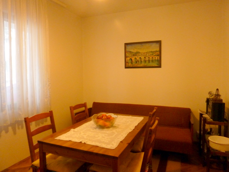 Gemütliches Wohnzimmer mit Esstisch und Sofa in einem zum Verkauf stehenden Haus in Sutomore, Montenegro.