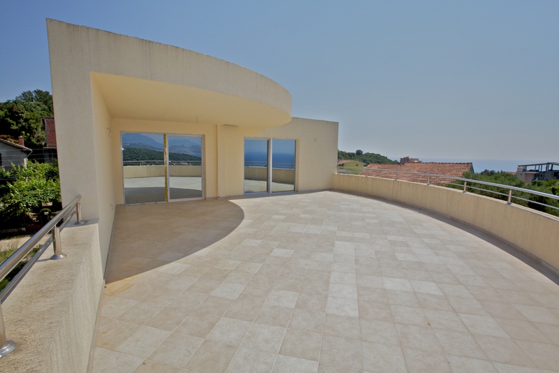 Geräumige Terrasse mit Panoramablick auf das Meer in einem Haus, Stadt Uteha, Montenegro. Helle Fliesen und moderne Geländer.